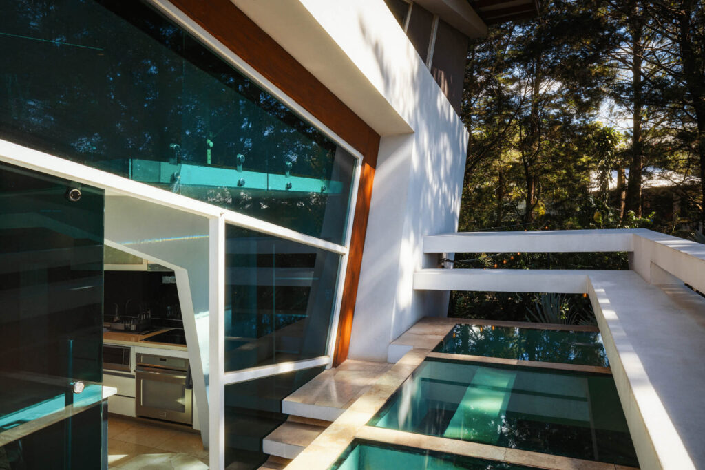 Terrace with jacuzzi and loungers framed by glass at Alianz Loft