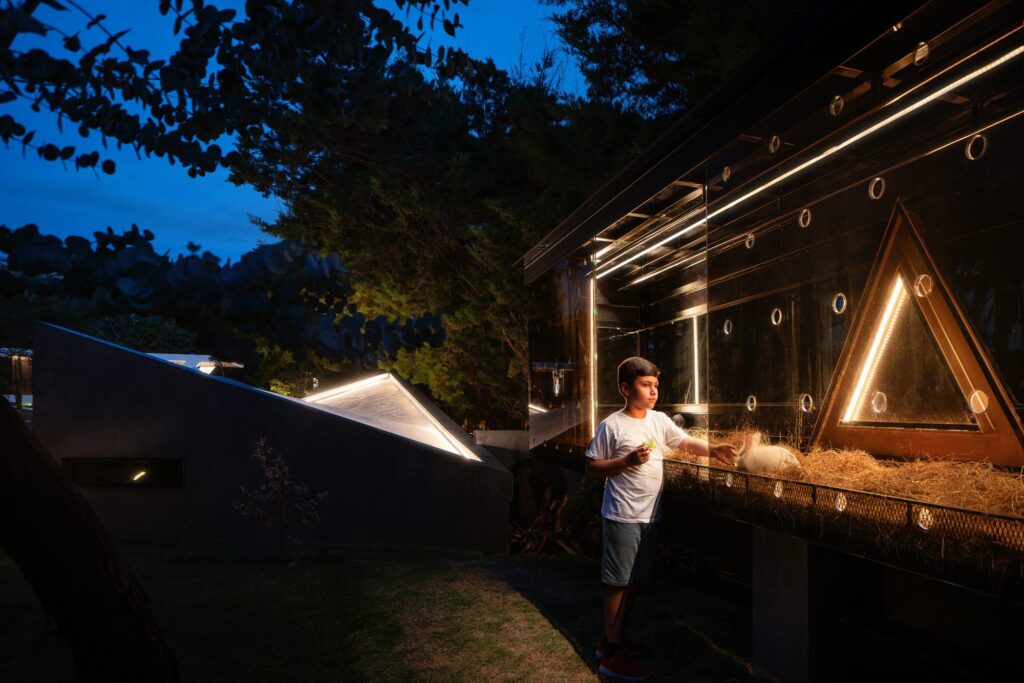 Floor-to-ceiling glass of a Nebulae Module at dusk, dissolving the line between interior and landscape