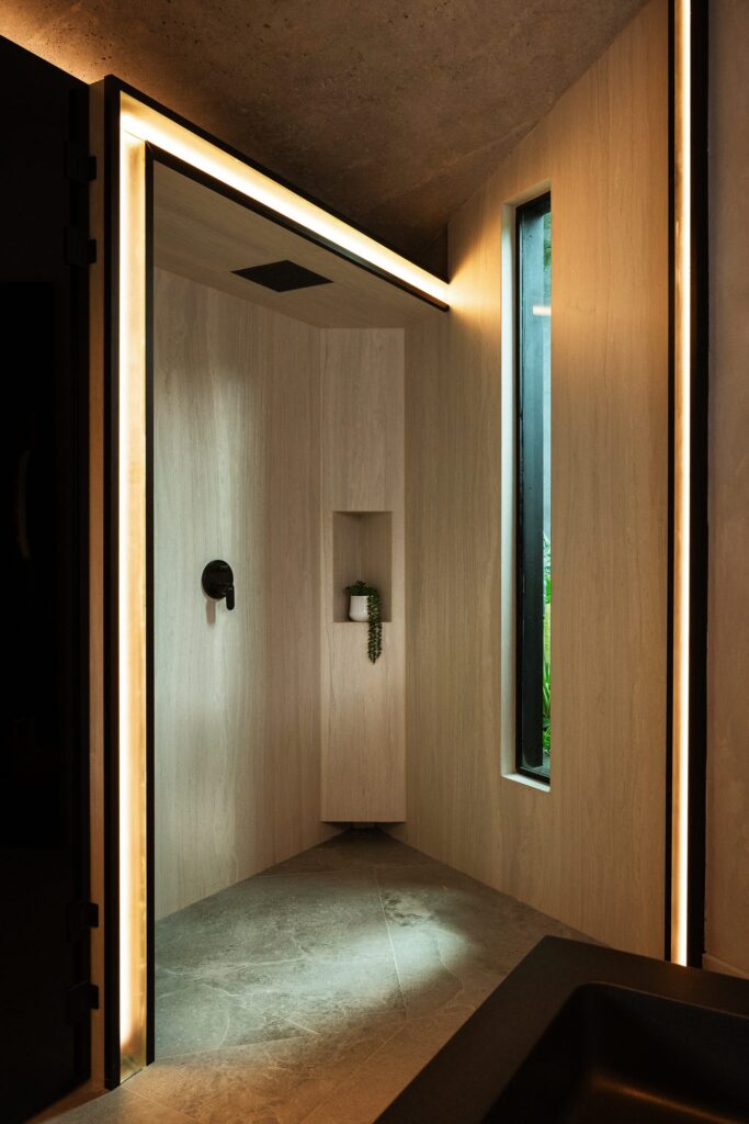 Minimalist warm-wood interior of a Nebulae Module with a vertical slot of natural light