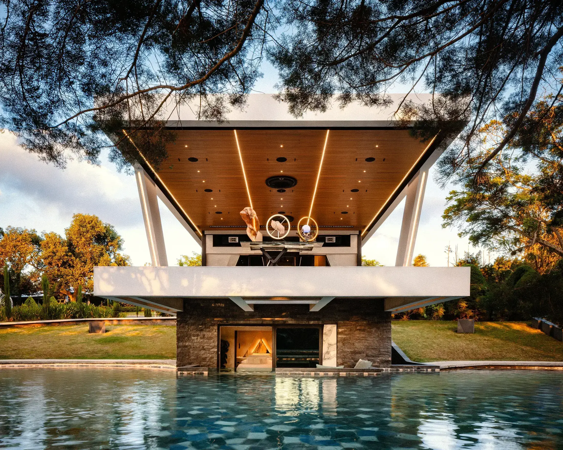 The Nebulae pavilion and Water Cube architecture mirrored in the pool at golden hour, Heredia, Costa Rica
