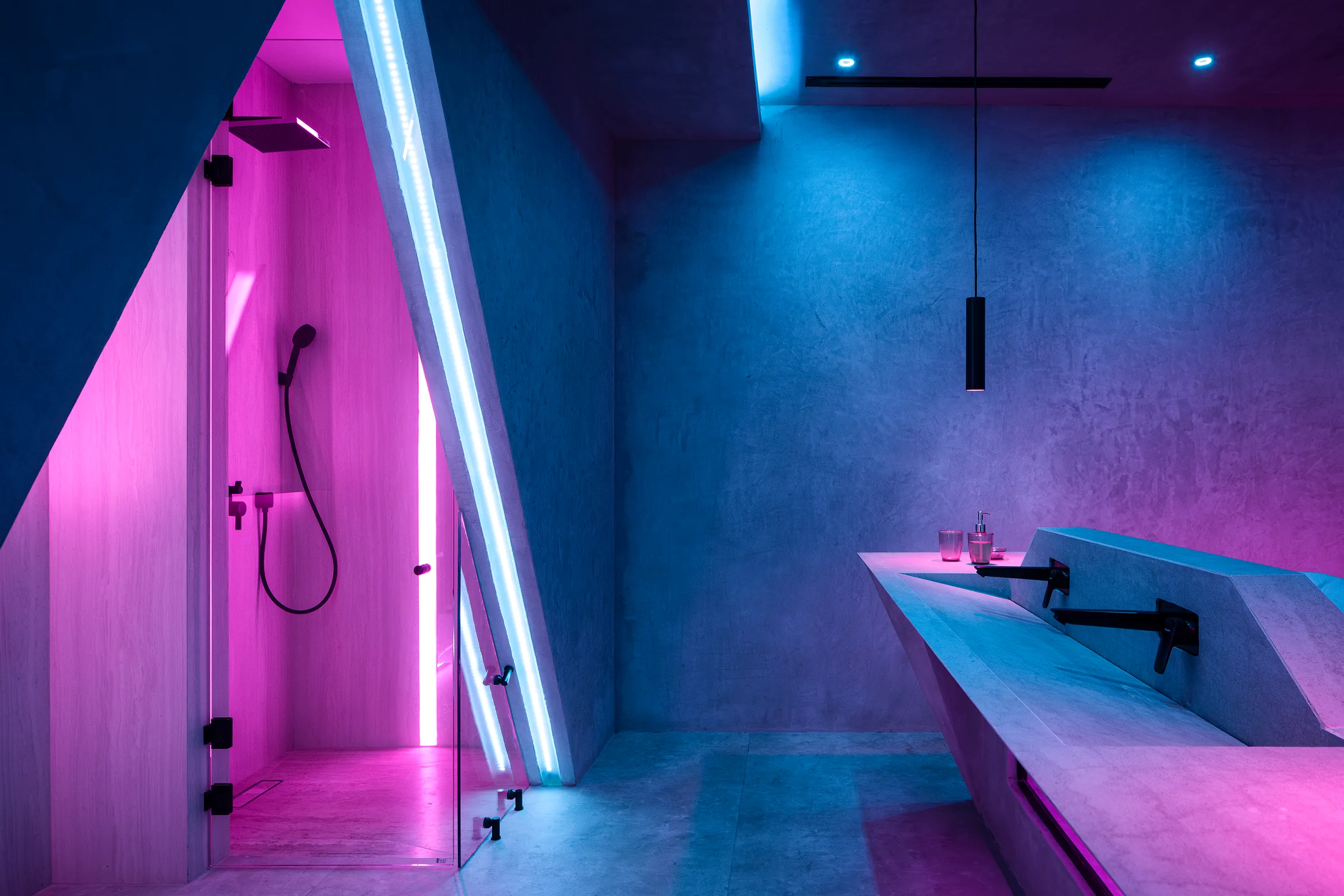 Marble bathroom lit in magenta with geometric detailing