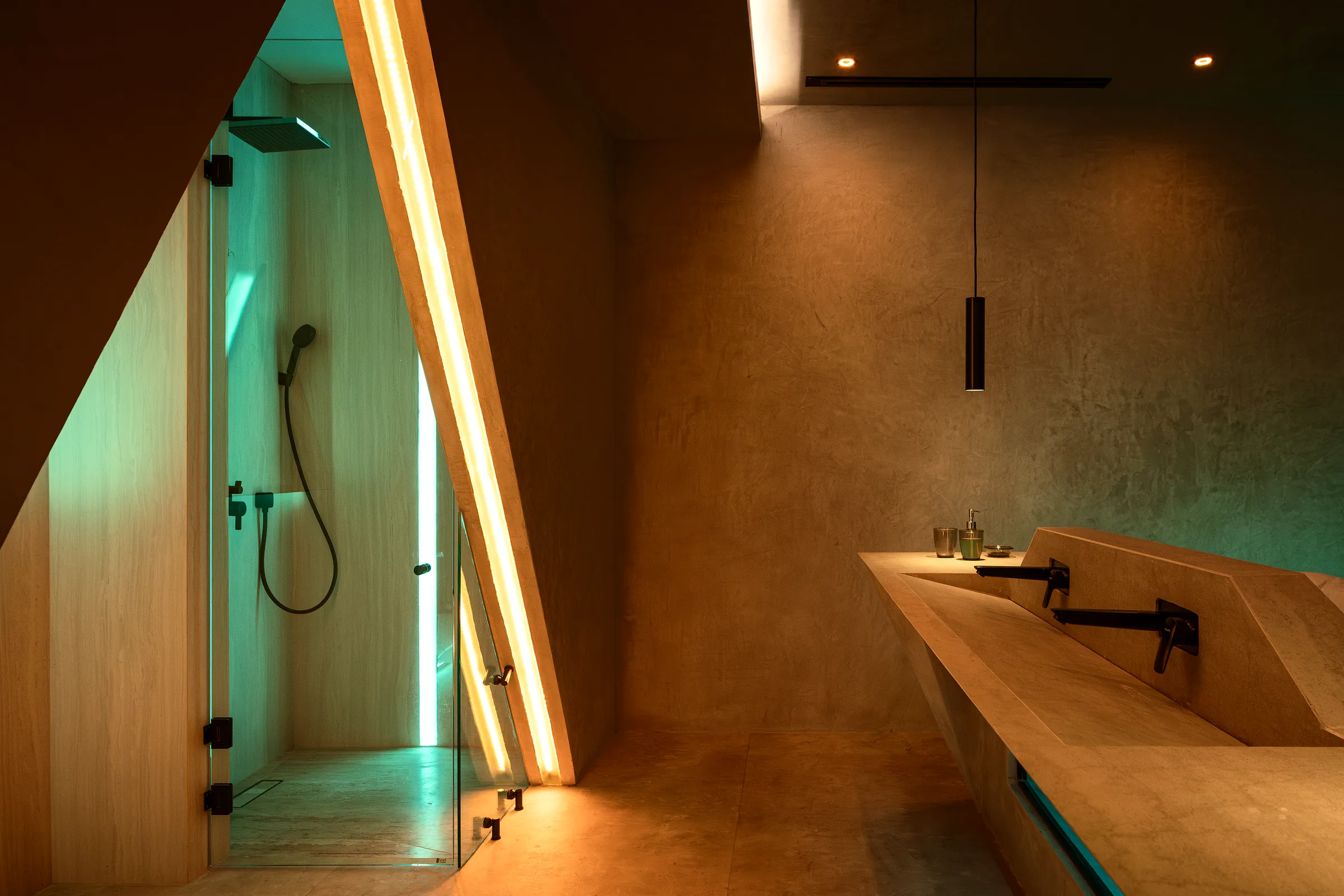 Marble bathroom with warm integrated lighting and exposed concrete in the Water Cube Suite