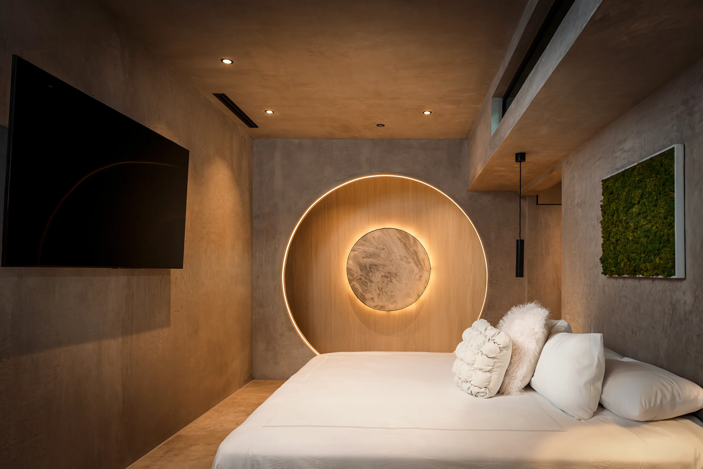 Circular geometric motif above a marble nightstand in the Water Cube Suite
