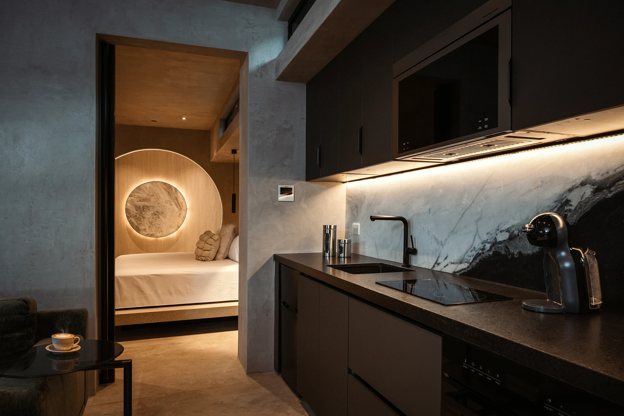 Fully equipped kitchenette with a circular mirror motif and marble surfaces