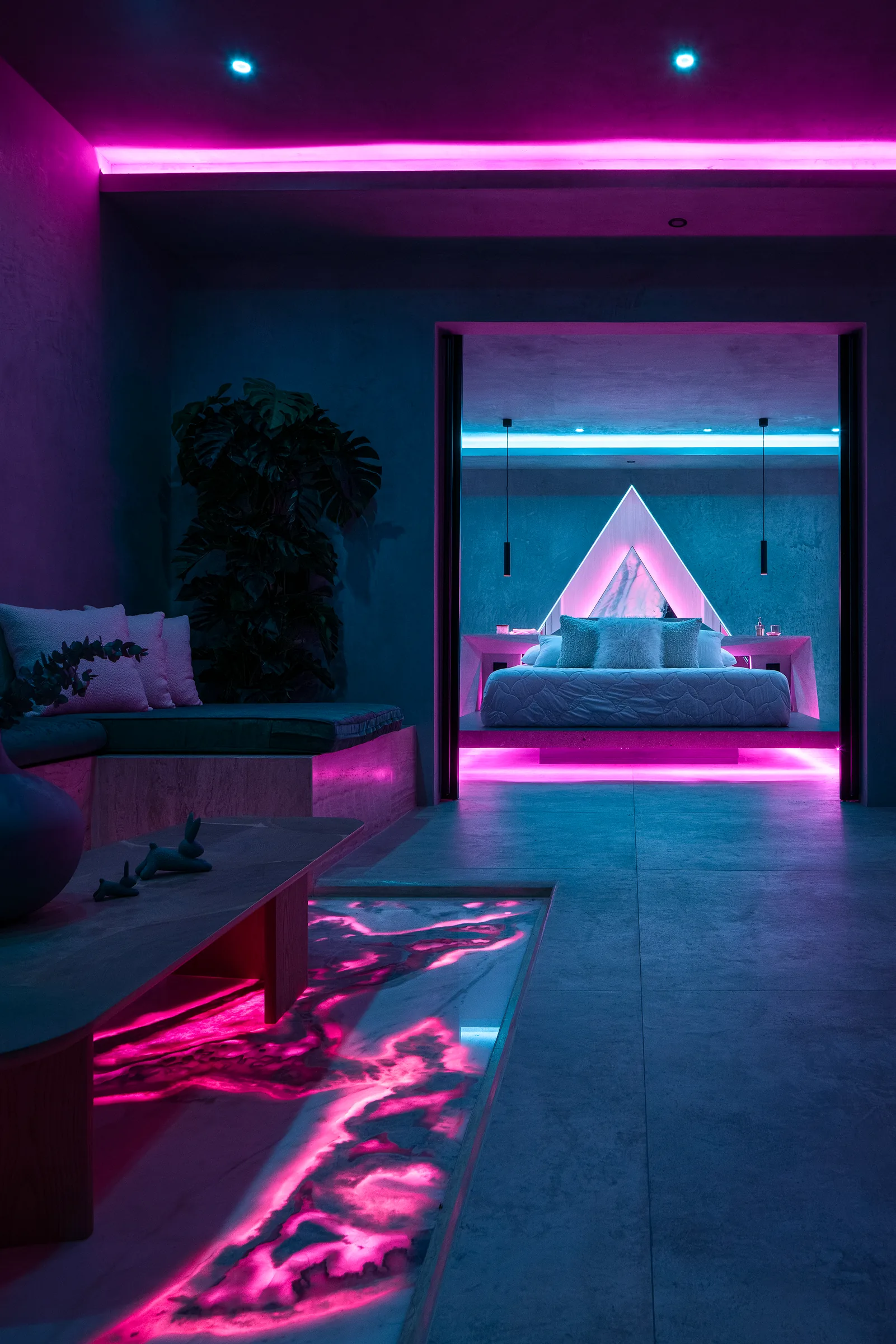 Marble portal with a triangular doorway lit in pink inside the Water Cube Suite