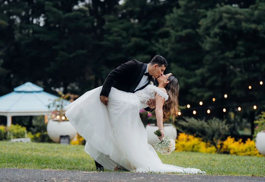 A bride and groom kissing in a dip in the gardens at Laureal Event Center