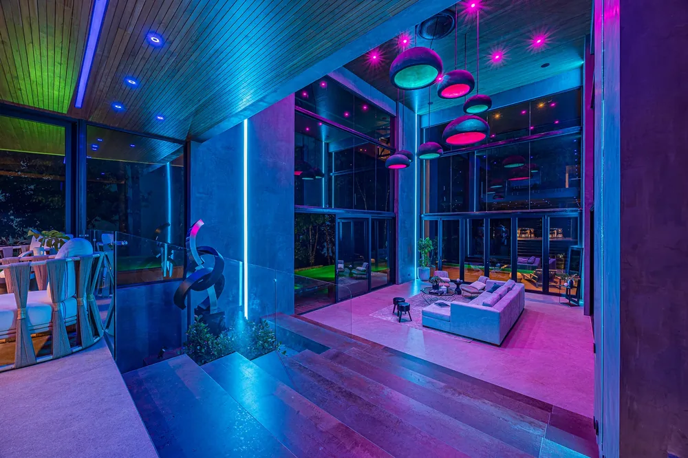 Open living space with sculptural ceiling and subtle scene lighting in an Alianz home