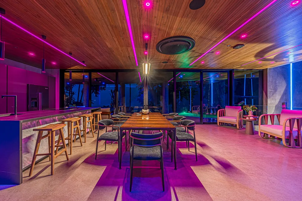 Bar and lounge corner glowing in violet and magenta scene lighting