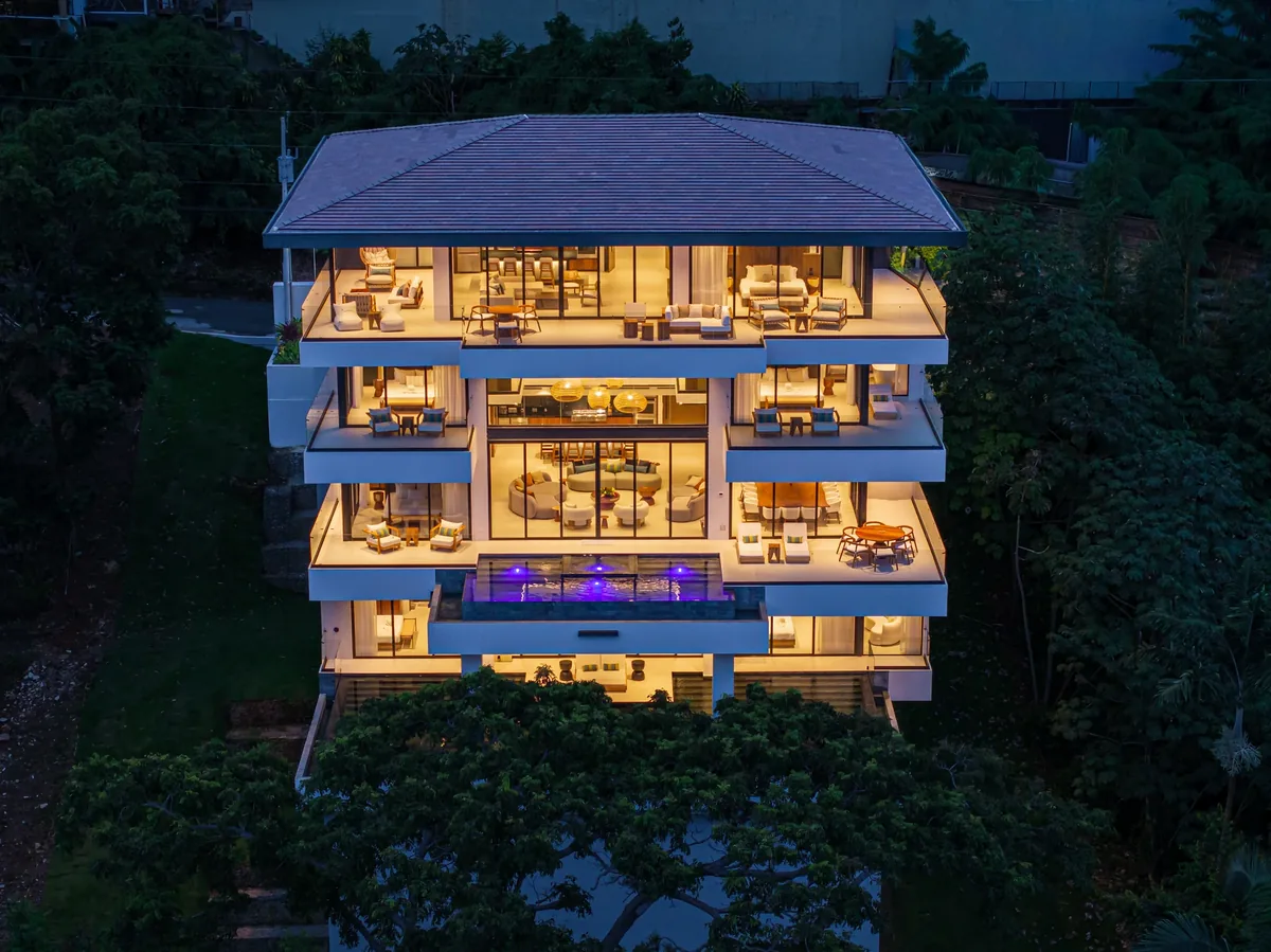 Terraced Alianz villa with warm interior lighting spilling onto balconies at night