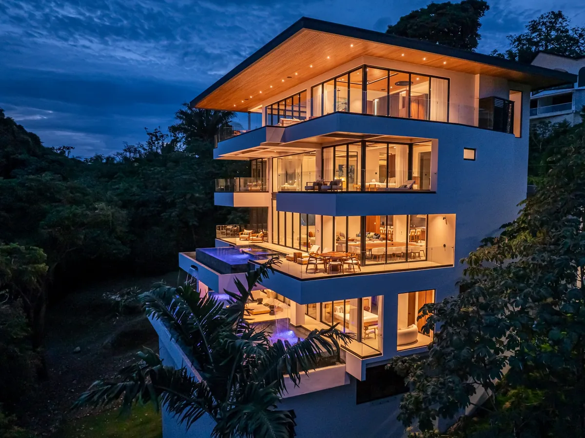 Alianz residence viewed from the garden at night, pool reflecting the lit facade