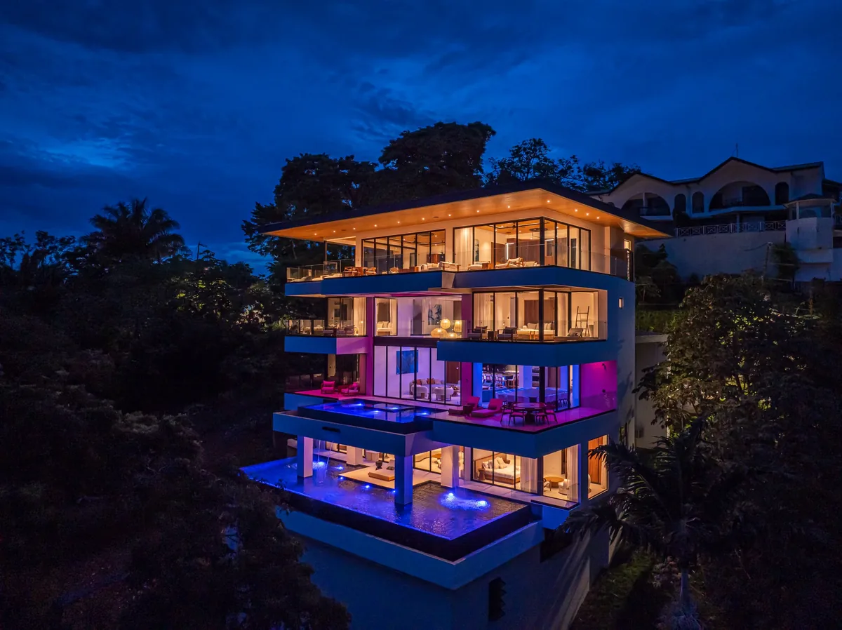 Alianz villa facade with layered architectural lighting against the night jungle
