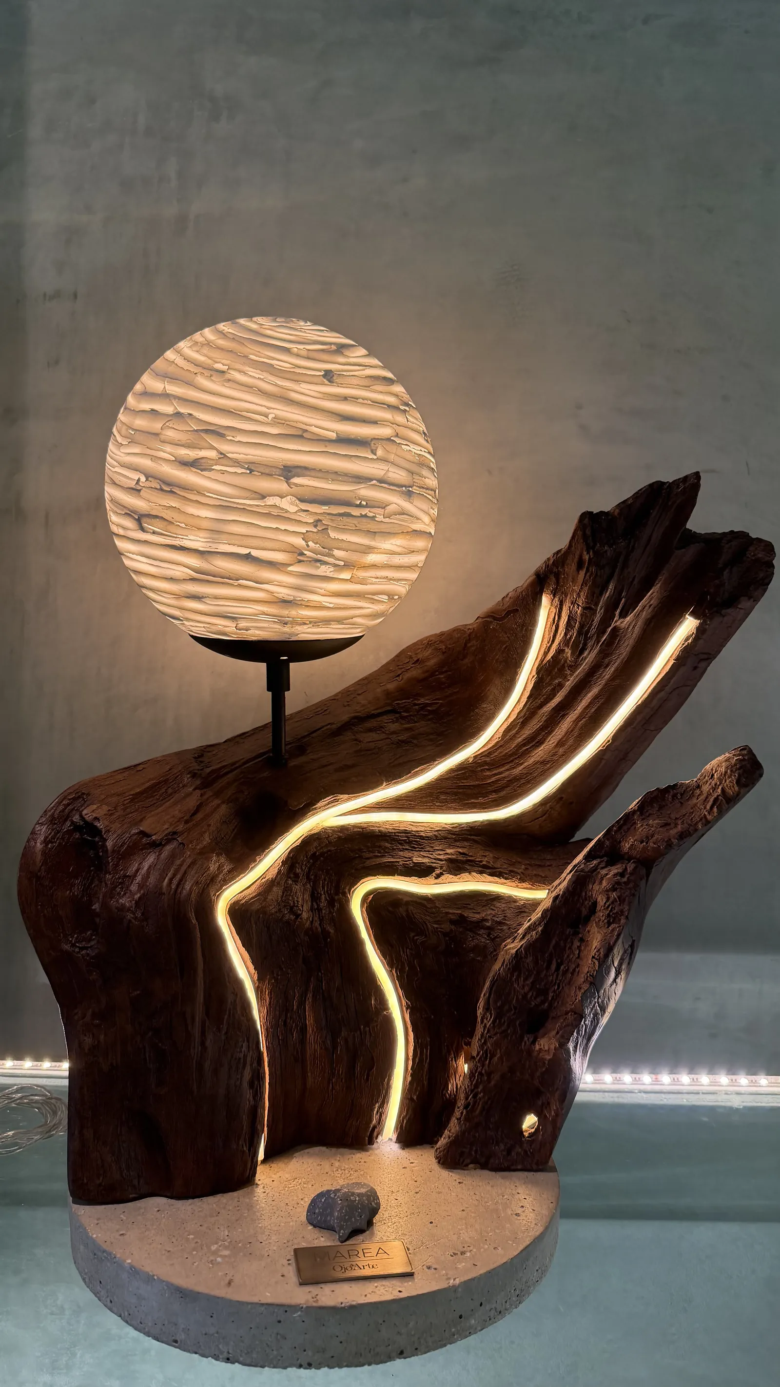 Marea — una ola de madera oscura abrazando una luna texturizada encendida