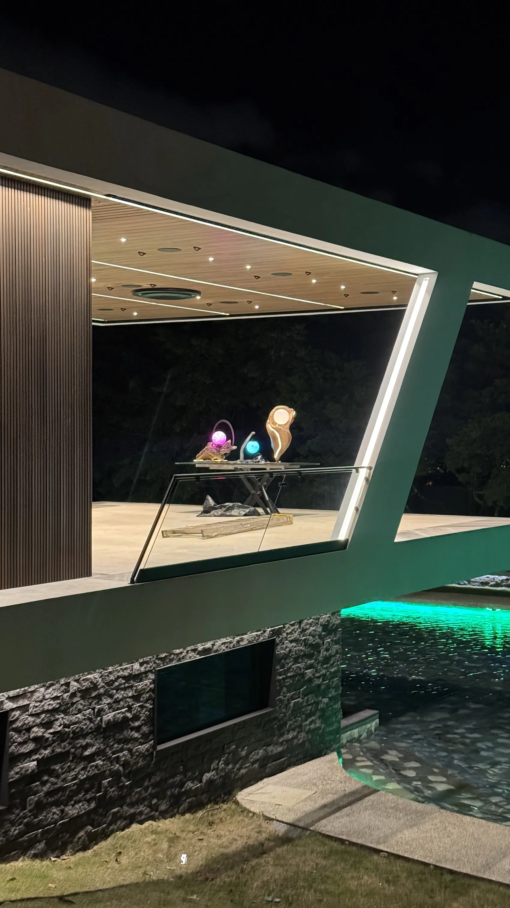 El pabellón de Nebulae de noche, con las esculturas encendidas dentro del marco de la arquitectura